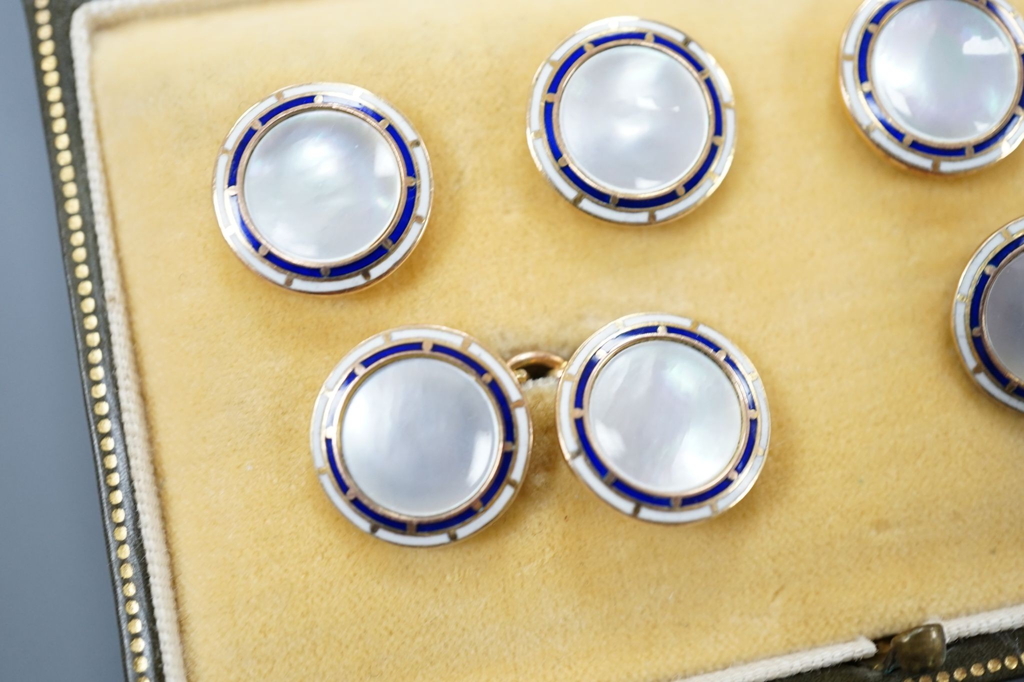 A cased 9ct, mother of pearl and enamel set six piece dress stud set, gross set 10.3 grams